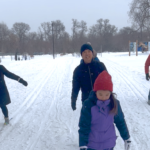 youth with red toque in front of a line of skiiers